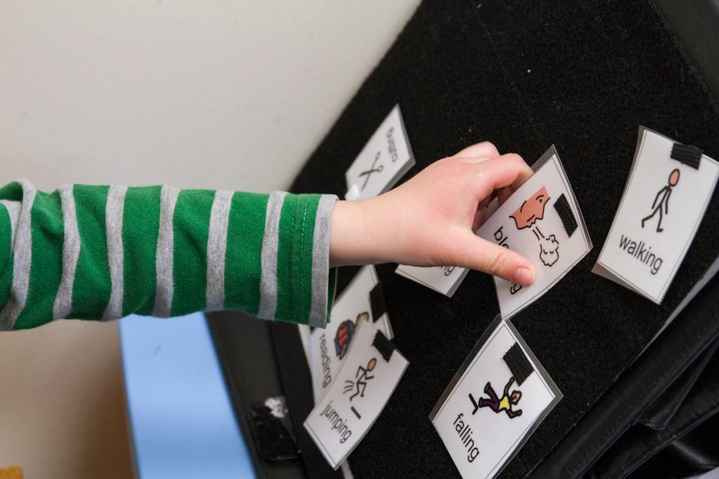 A child playing with flashcards as part of a speech therapy regimen.