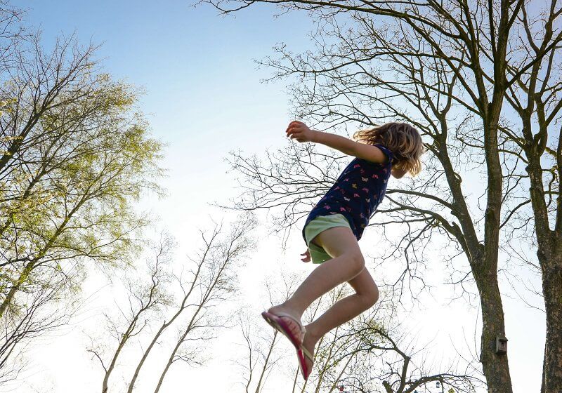 a girl jumping on a trampoline