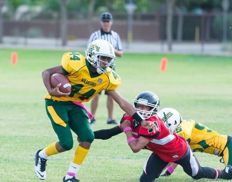 two adolescents playing football