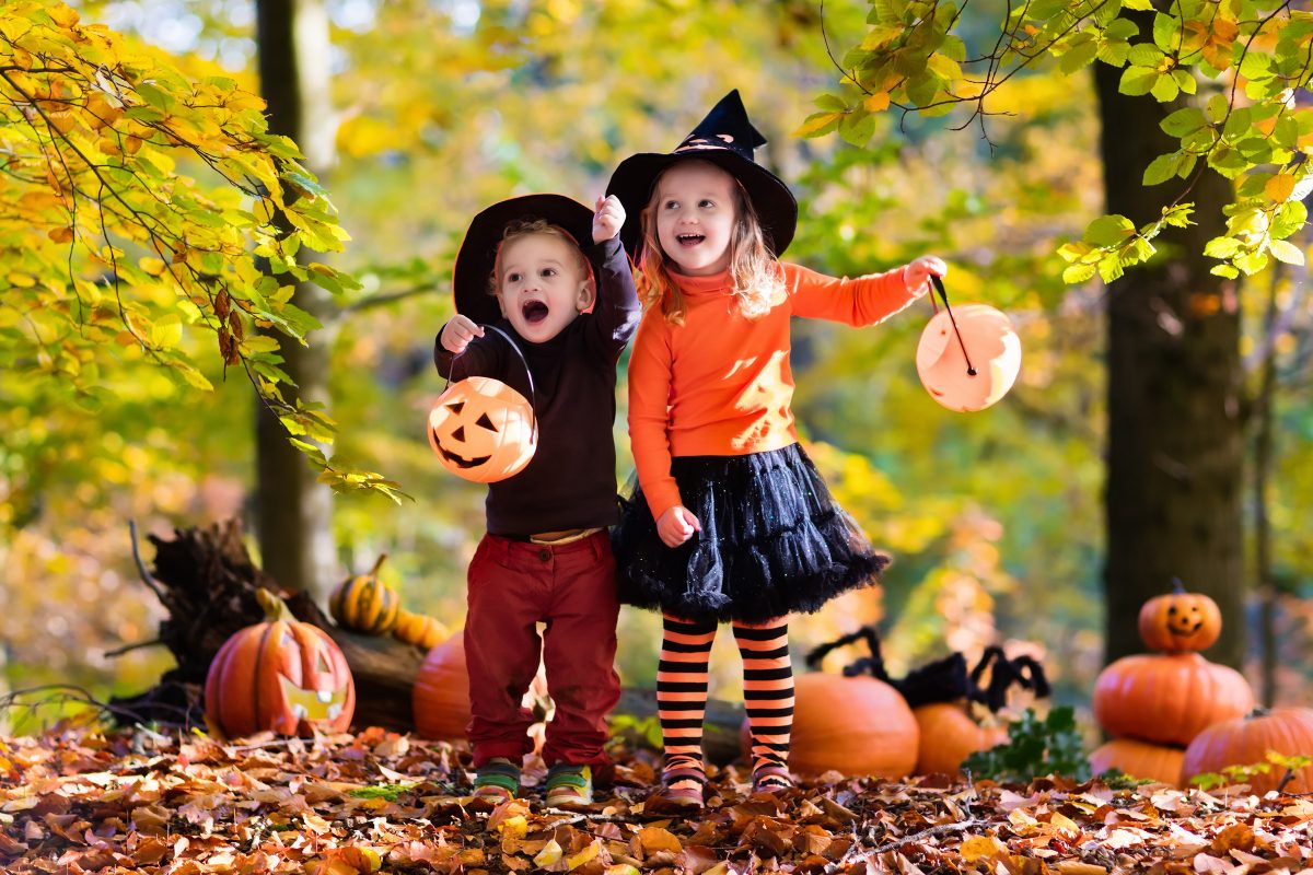 Children having fun partaking in Halloween activities. They are wearing costumes and going trick-or-treating.