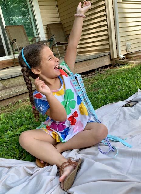 Smiling girl creating hand kite