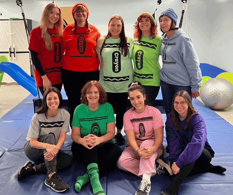 Group picture of Torrington crew smiling in the therapy gym