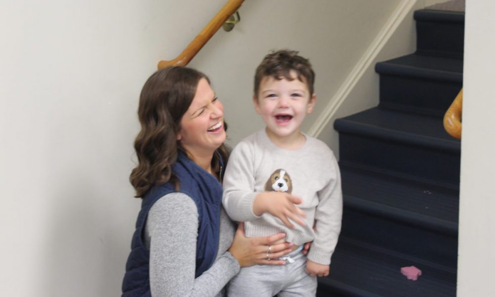 woman laughing with child on stairs