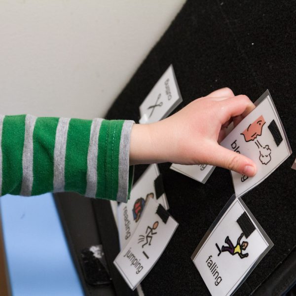 A child playing with flashcards as part of a speech therapy regimen.