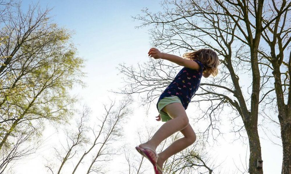 a girl jumping on a trampoline