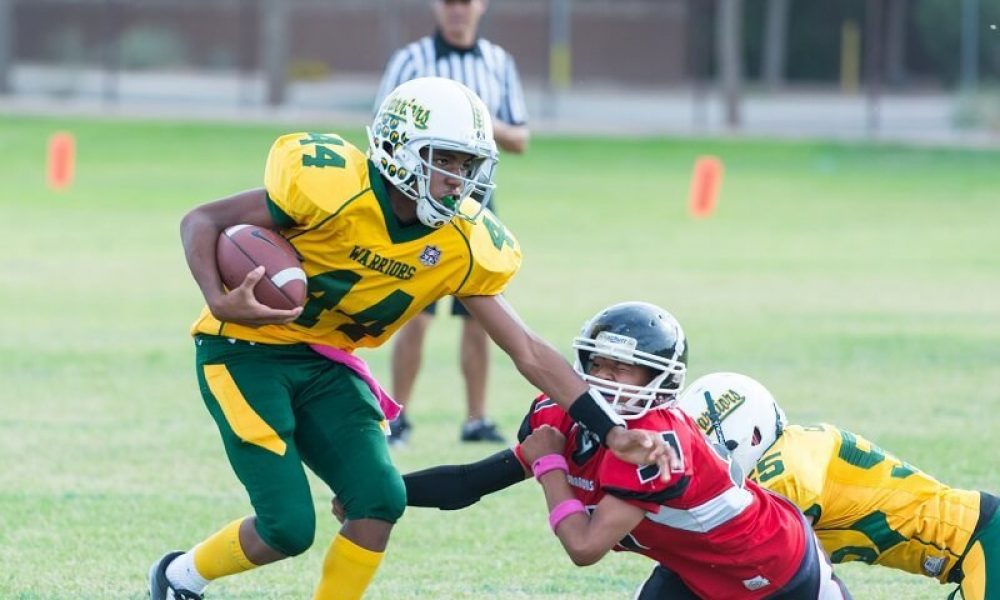 two adolescents playing football